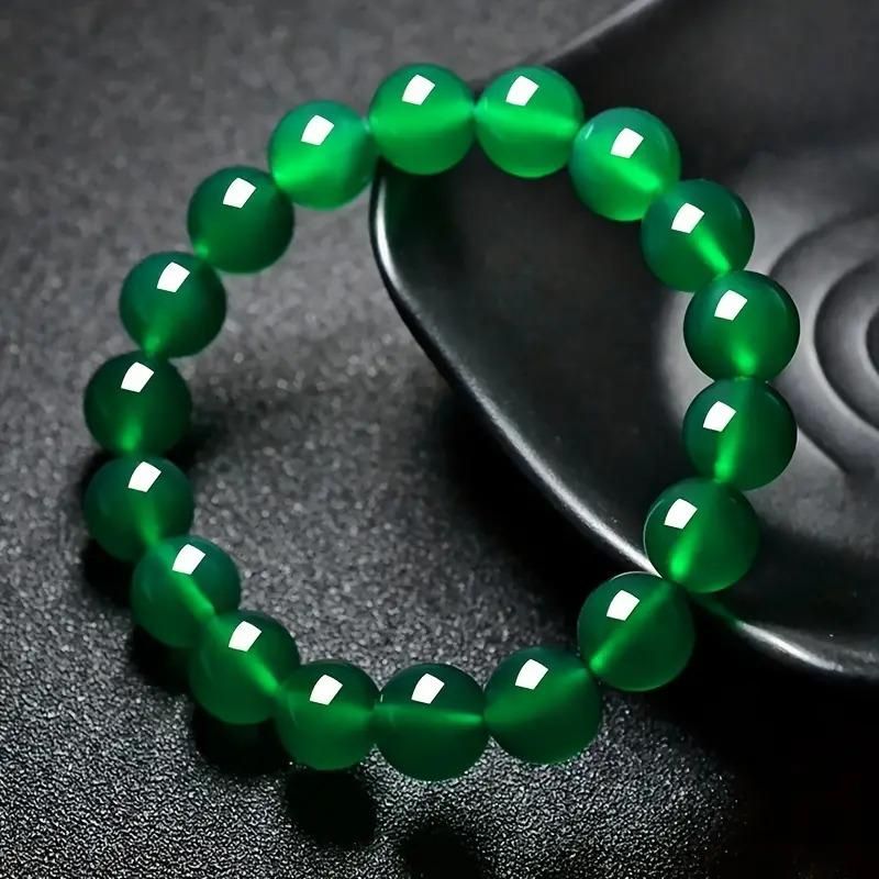 Green beaded bracelet on a dark textured surface