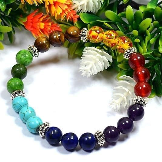 Multicolored beaded bracelet with green, blue, purple, and red beads on a white background with flowers.