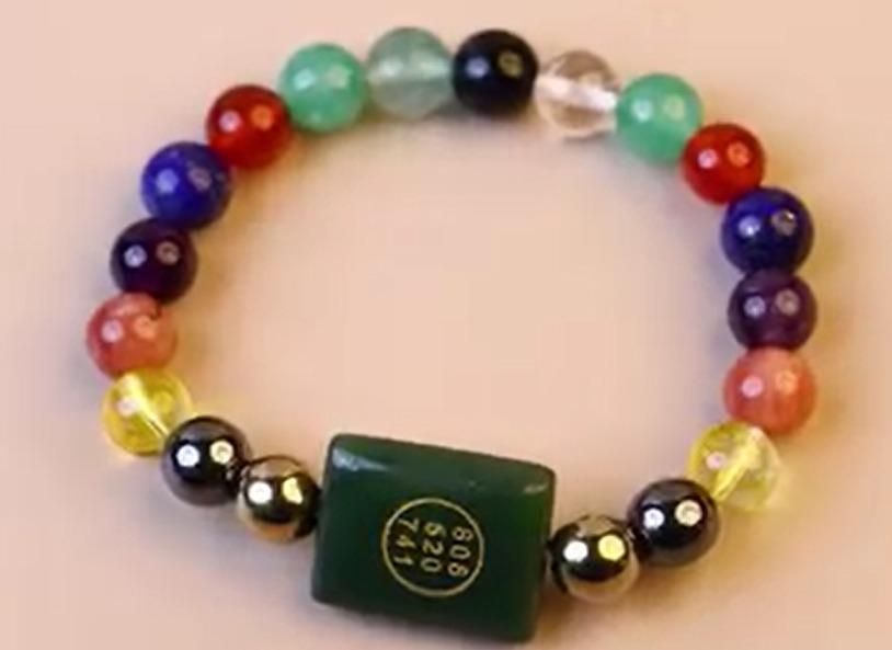 Natural Gemstones Zibu Bracelet, Multicolored beaded bracelet with a green square charm on a beige background