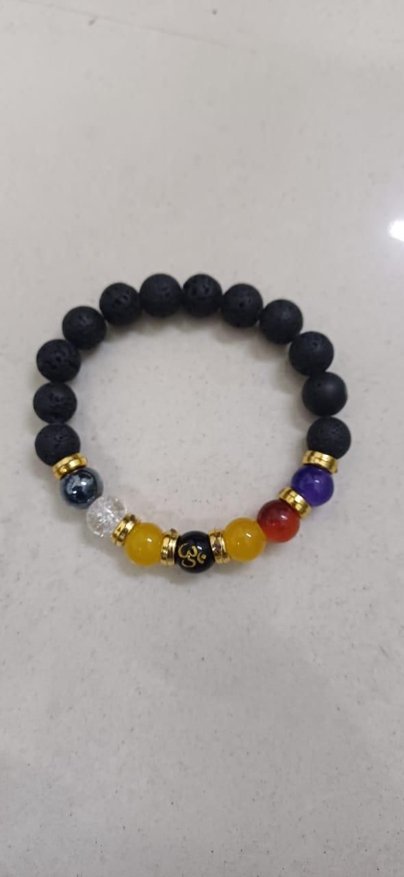 Round natural stone beads strung together into a handcrafted spiritual bracelet, highlighted by a hanging Om charm